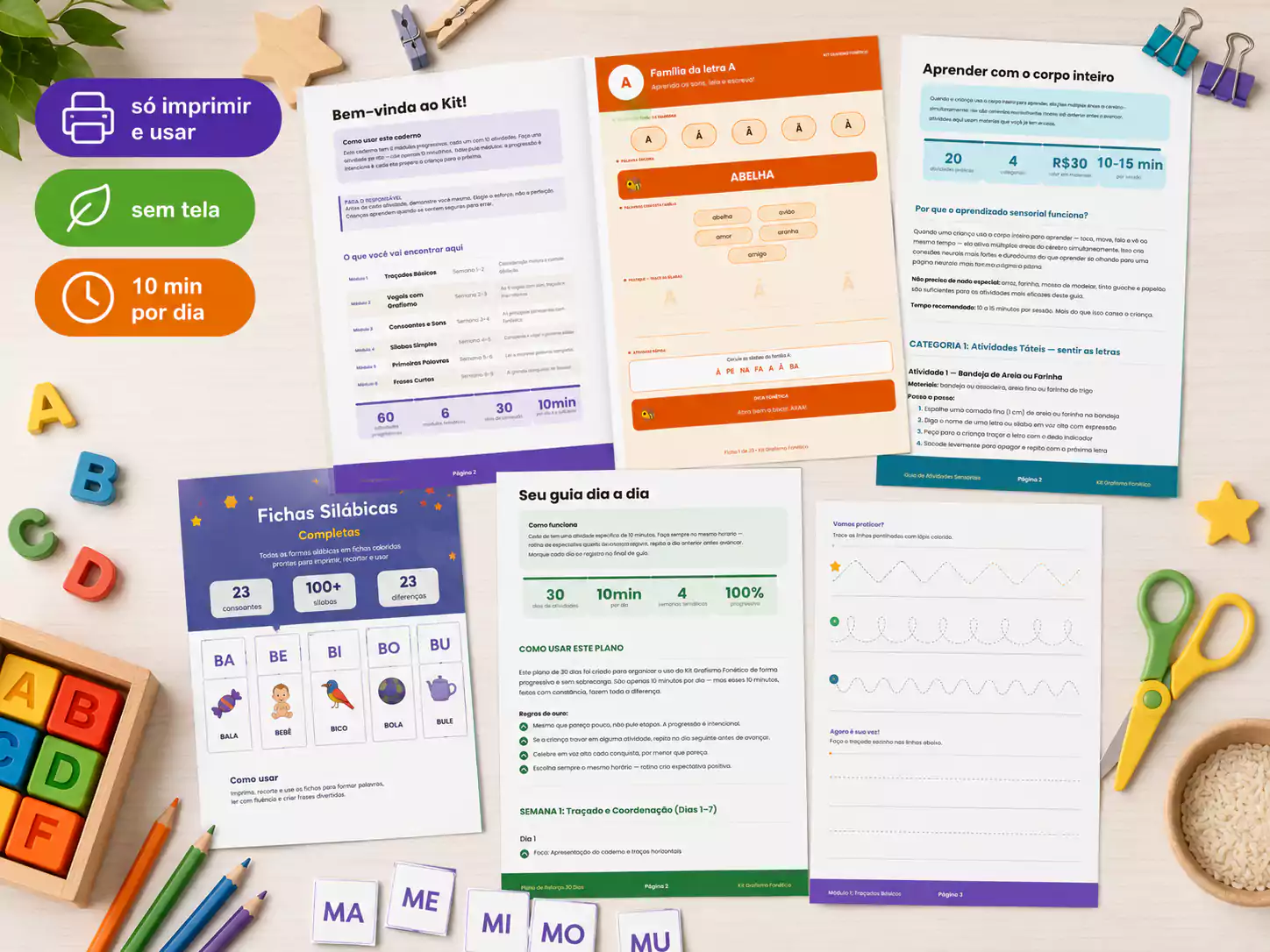 Páginas impressas do Kit Grafismo Fonético — fichas silábicas, caderno e atividades espalhados numa mesa com materiais escolares